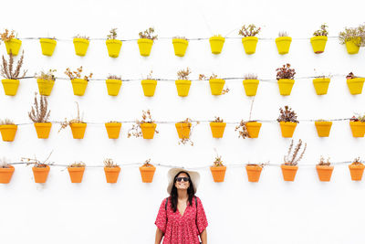 Full length of woman standing against wall