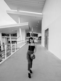 Full length portrait of smiling girl standing in building