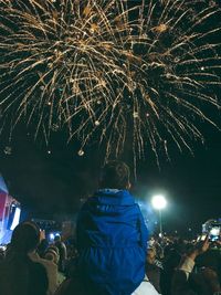 Rear view of firework display at night
