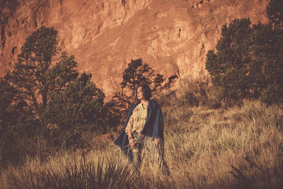 Woman standing on field against mountain