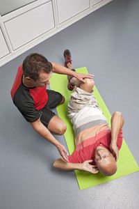 Personal trainer helping client in gym