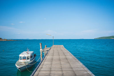 Pier over sea against blue sky