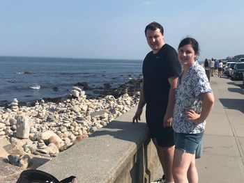 Full length portrait of friends standing on beach