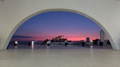 People on tiled floor against clear sky at sunset