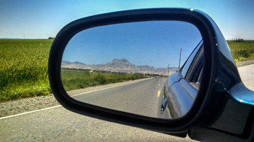 Reflection of road on side-view mirror of car