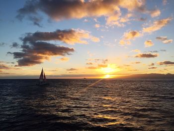 Silhouette sailboat sailing on sea against sky during sunset