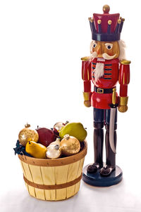 Close-up of fruits in basket on table against white background