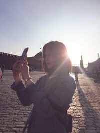 Woman photographing against clear sky