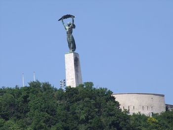 Low angle view of statue against blue sky