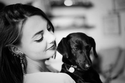 Close-up of beautiful young woman holding dog