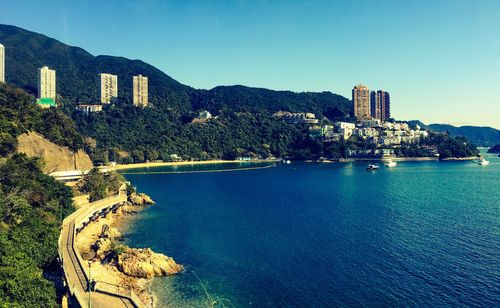 Scenic view of sea by mountains against clear sky