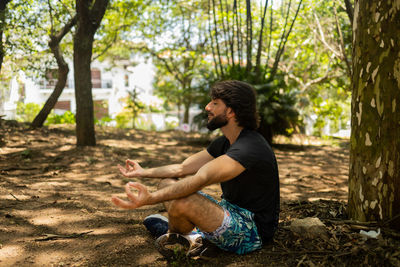 Man meditating. yoga and meditation on a sunny.day at a park. feel good, healthy, spiritual concept.