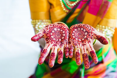 Midsection of bride showing henna tattoo