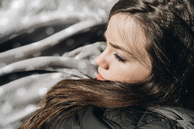 Close-up of young woman relaxing in bed