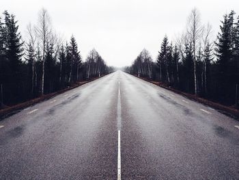 Empty road along trees