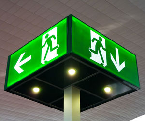 Low angle view of illuminated directional sign