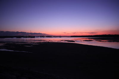 Scenic view of beach against sky at sunset