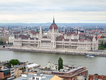 Buildings in city against cloudy sky