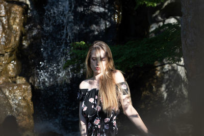 Beautiful woman standing by plants outdoors