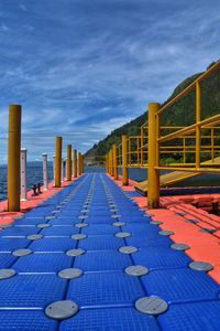 Empty footpath against blue sky