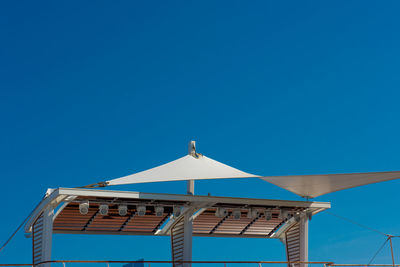 Low angle view of awning against clear blue sky