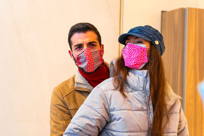 Portrait of young couple against wall