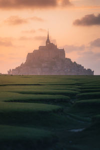 Scenic view of mont saint michel against sky during sunset