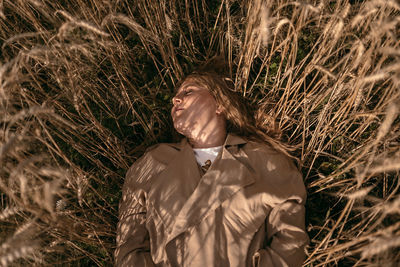 Portrait of young woman lies against hay