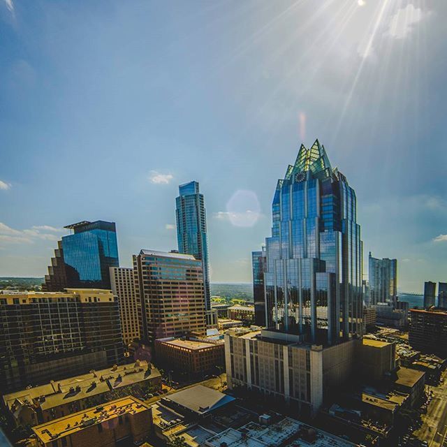 building exterior, architecture, built structure, sunbeam, sun, city, sunlight, lens flare, sky, sunny, cityscape, skyscraper, cloud - sky, modern, residential building, building, day, outdoors, office building, blue