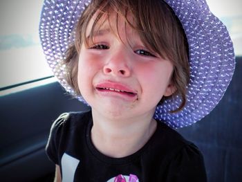 Close-up portrait of girl crying while traveling in car