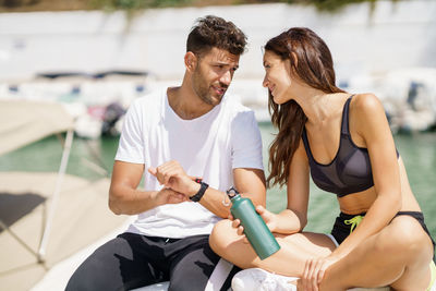 Friends talking to each other while sitting outdoors