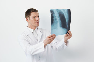 Doctor holding stethoscope against white background