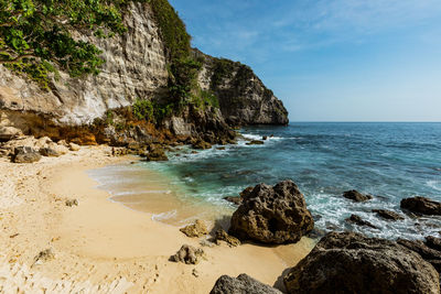 Scenic view of rocky beach against sky