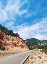 Road by mountain against sky