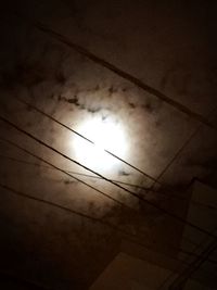 Low angle view of silhouette electricity pylon against sky