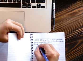 Midsection of person using laptop on table