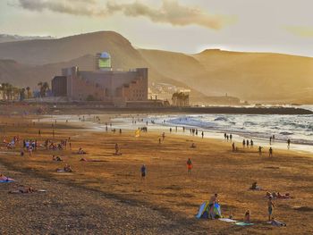 People at beach against sky