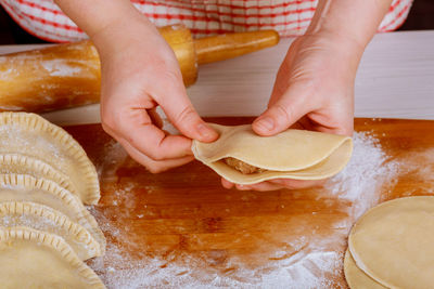 Cropped hands of woman preparing food on cutting board