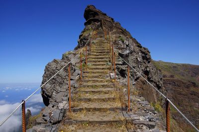 Low angle view of steps on mountain against blue sky