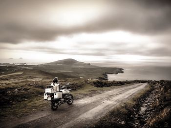 Rear view of man riding motorcycle on road