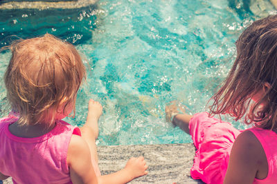 High angle view of girls sitting at poolside