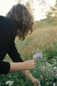 Boy holding flowers on field