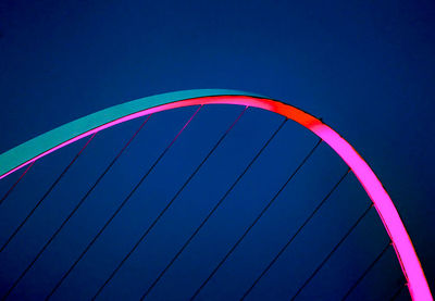 Low angle view of multi colored city against blue sky