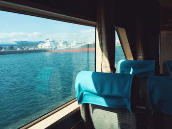 Close-up of chair by sea against sky