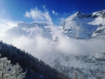 Low angle view of snow mountains against sky