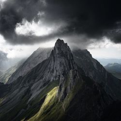 Scenic view of mountains against cloudy sky