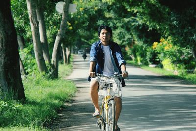 Portrait of man riding bicycle on road