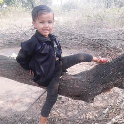 Full length of smiling boy standing on land