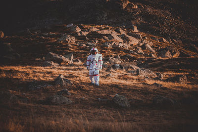 Rear view of woman walking on rock