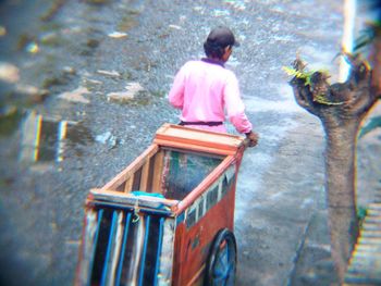 Rear view of woman sitting outdoors